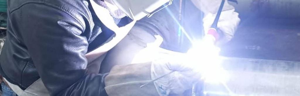 Soldador ejecutando soldadura TIG en taller